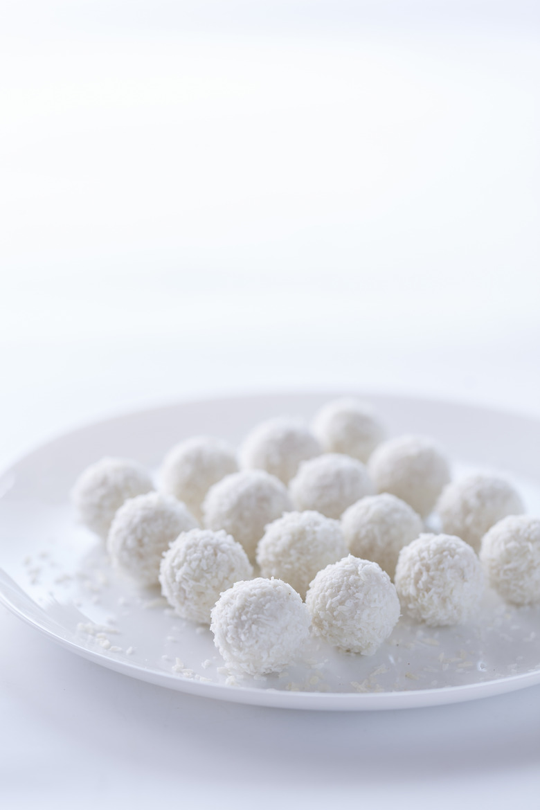 Coconut cake balls sitting on a plate.