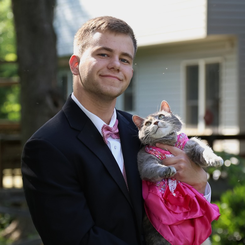 Guy and his cat as his prom date wearing a pink dress.