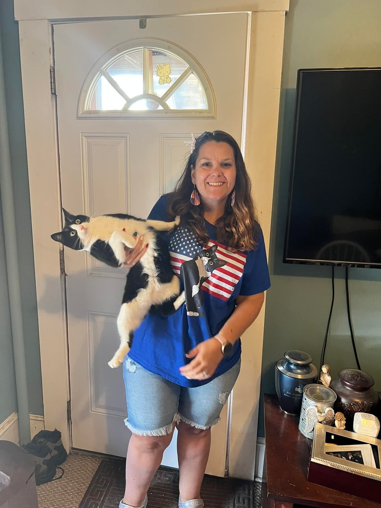 cat leans away from woman holding her