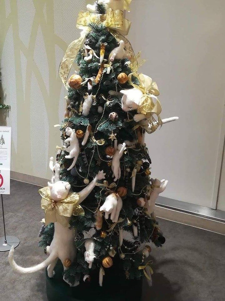 Christmas tree decorated with felts cats climbing all around it