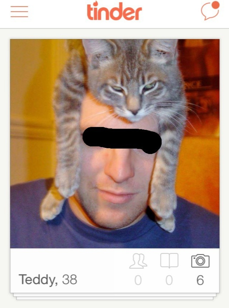 Man wears cat on head like hat