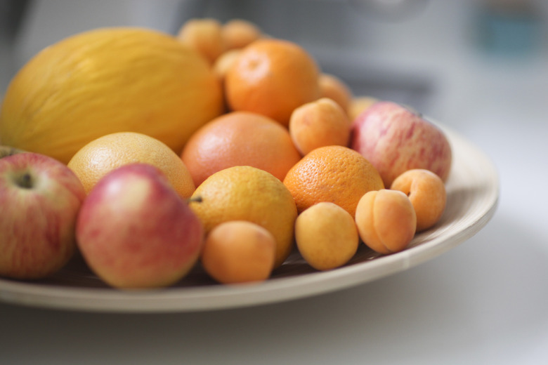 Plate of fresh fruit in kitchen, close up