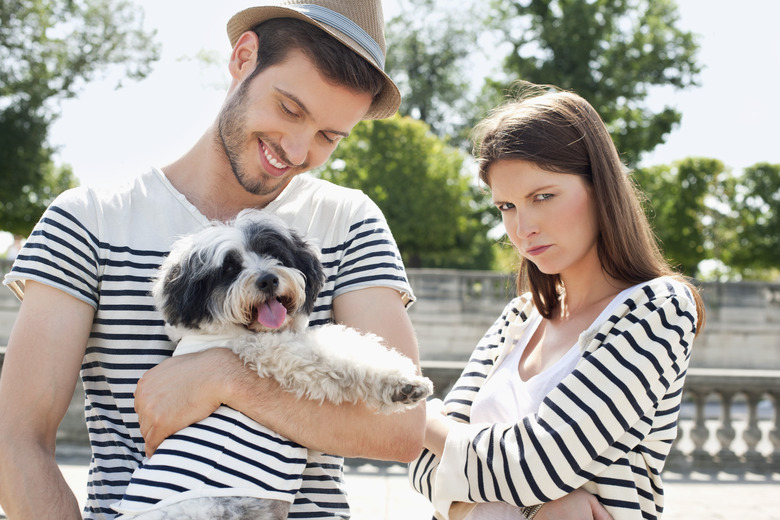 Man carrying a puppy and smiling with a woman looking sad, Paris, Ile-de-France, France