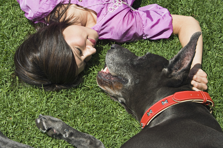 Woman and Great Dane lying on grass