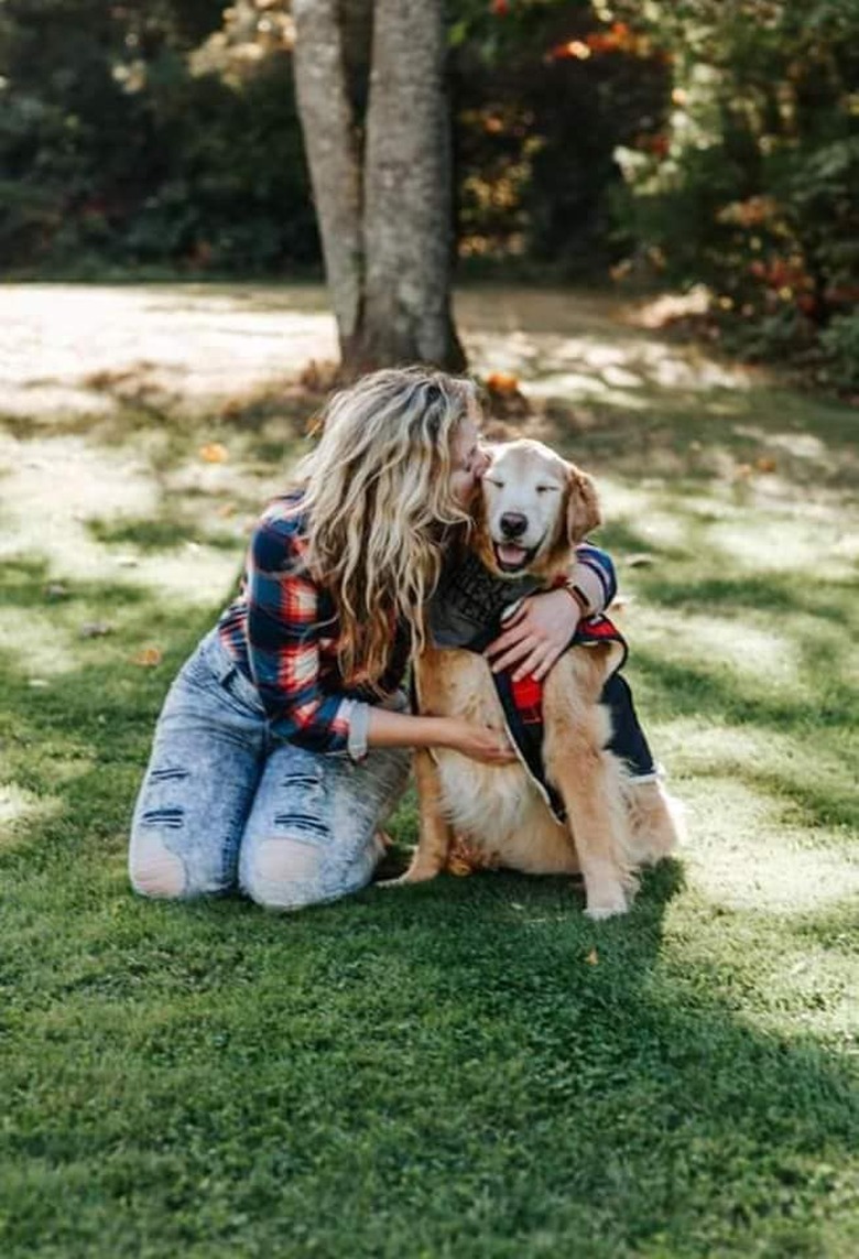 woman hugs smiling dog