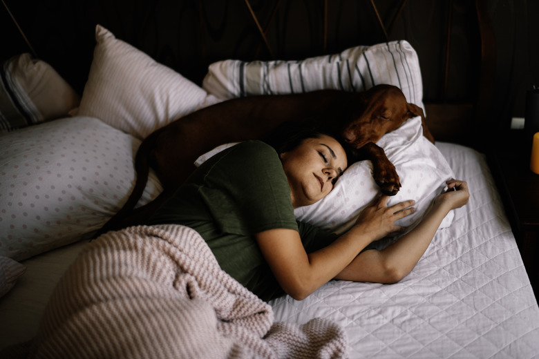 Girl sleeping with her dog.