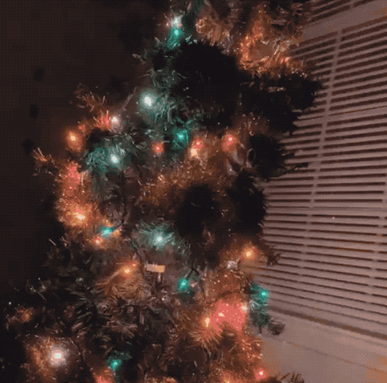 gif of cat jumping onto christmas tree