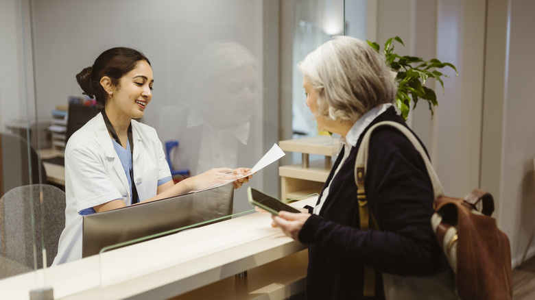 lady booking an appointment at reception desk