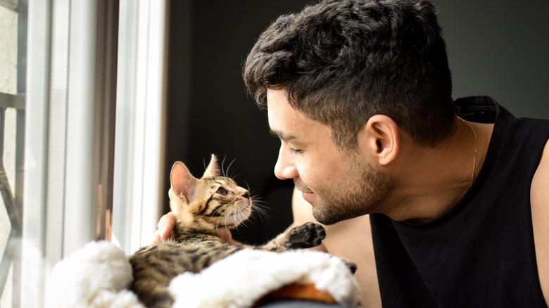 man looking into cat's eyes