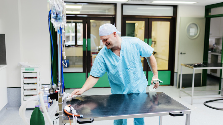 a smiling worker cleaning a vet clinic exam table