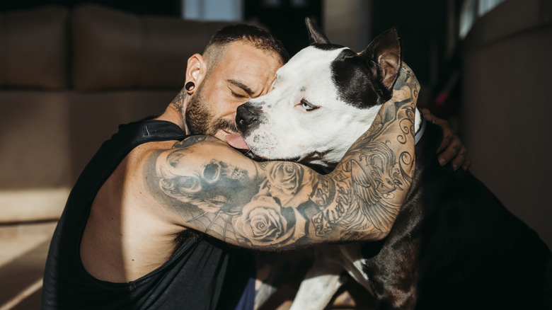 muscular man hugging his dog