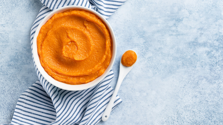 bowl of mashed pumpkin on blue-striped cloth napkin