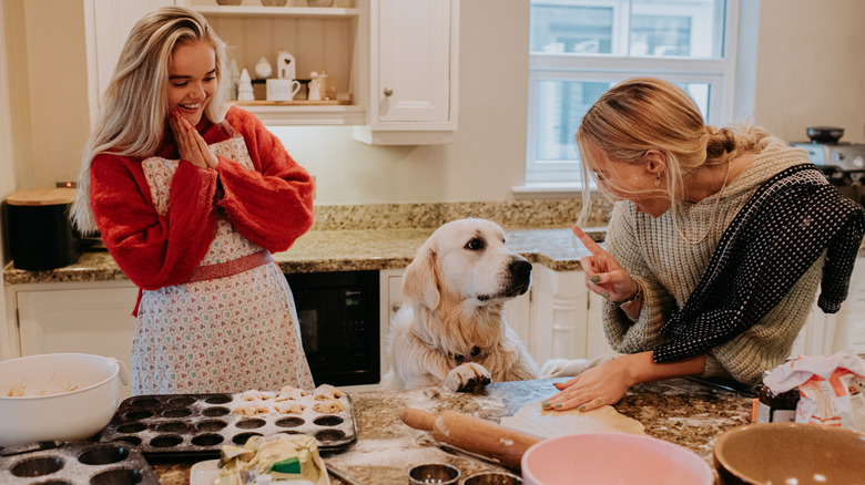 two women baking in kitchen with dog