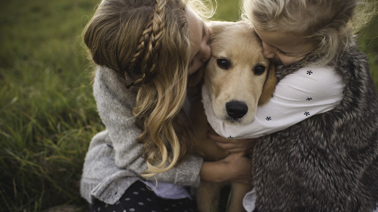 kids hugging golden retriever