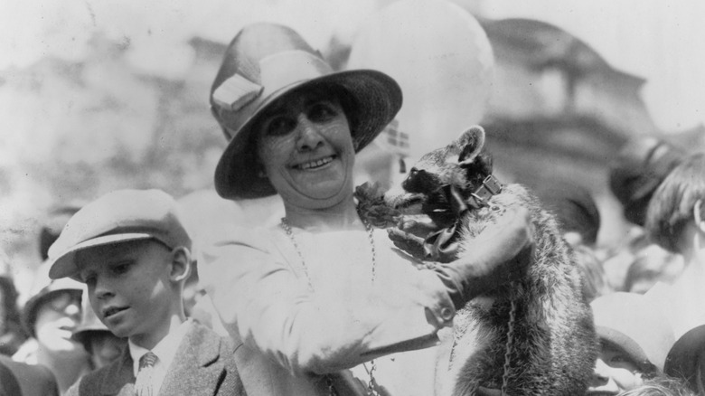 First Lady Coolidge holding Rebecca the Racoon surrounded by children