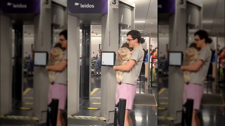 A man carrying two cats at TSA checkpoint