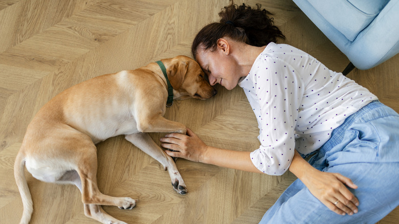 Dog and woman sleeping on floor