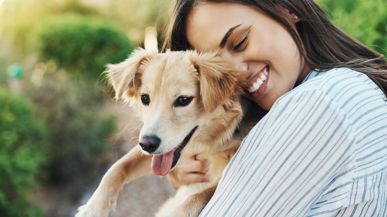 A woman hugging a puppy.