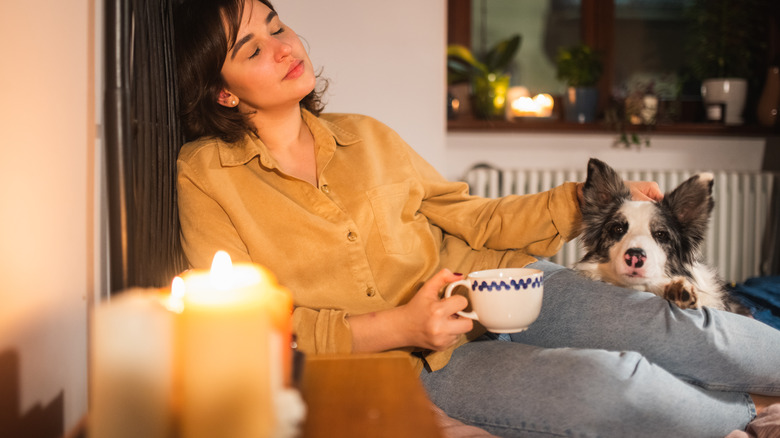 owner and dog sitting behind a lit candle