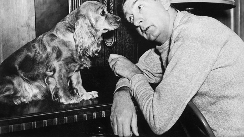 A man listens to the radio with his cocker spaniel in the early 1900s