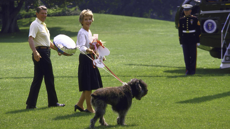 President Ronald Reagan and First Lady Nancy Reagan prepare to board a helicopter with their dog, Lucky