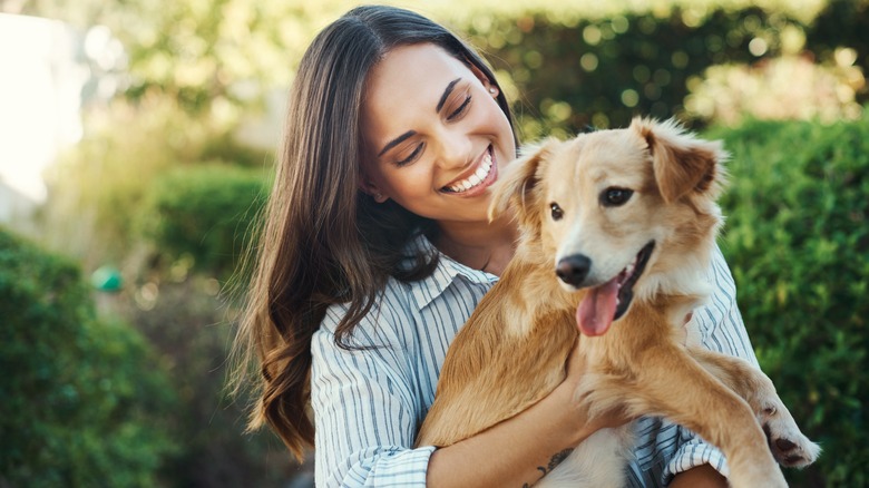 woman holding a dog outside