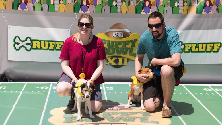 A couple with their two dogs participating in a pre-Puppy Bowl event